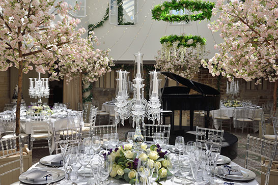 Ellenborough Park wedding, inside the main dining room, crystal candelabra, piano and blossom trees