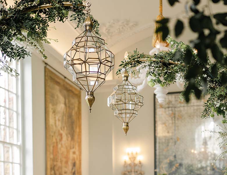 Elegant Gold Moorish Lanterns suspended on gold stands covered in foliage
