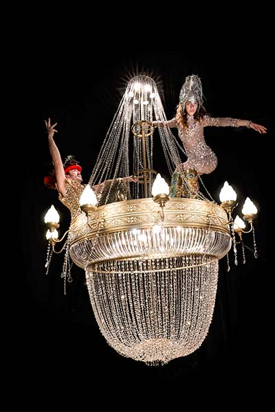 Two performers in a giant chandelier built for cabaret shows